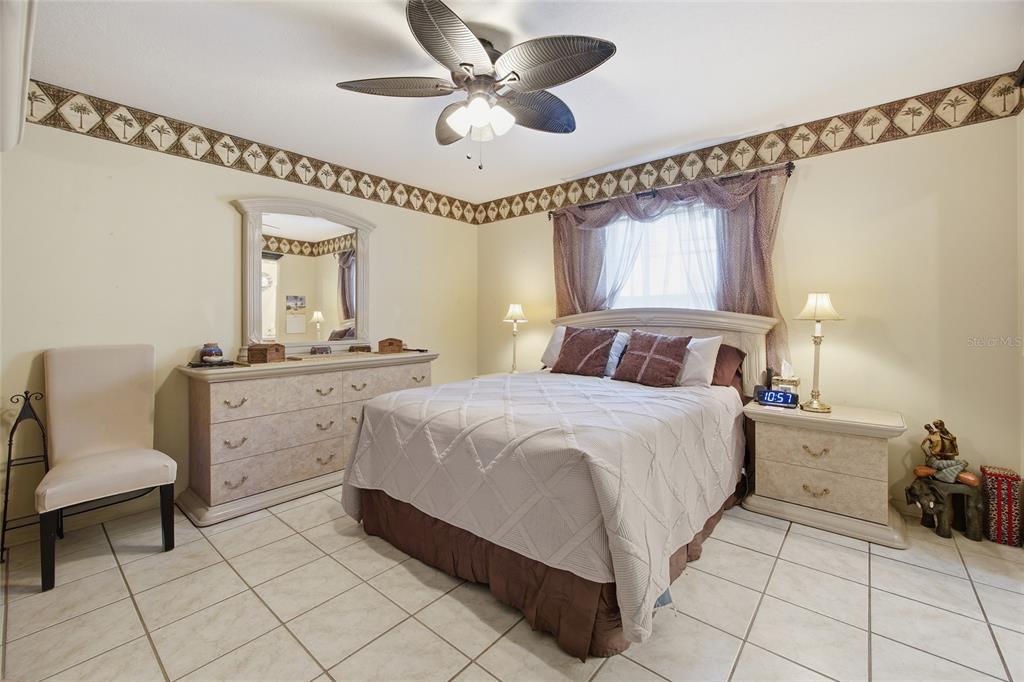 549 Silver Course Run Ocala, FL 34472 - Photo 22 of 48 a bedroom with a bed and a chandelier