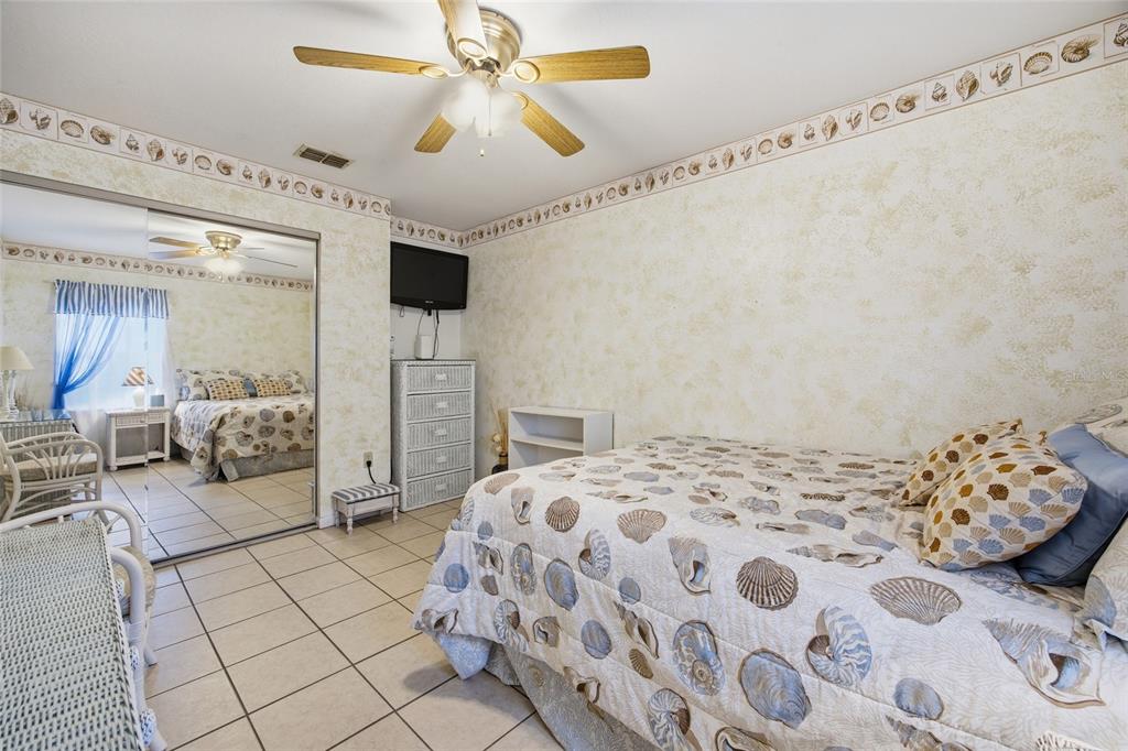549 Silver Course Run Ocala, FL 34472 - Photo 26 of 48 a bedroom with a bed and a chandelier