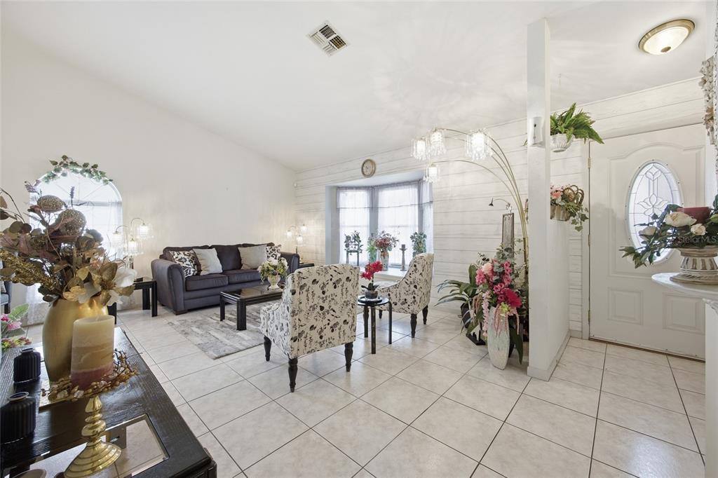 549 Silver Course Run Ocala, FL 34472 - Photo 6 of 48 a living room filled with furniture a chandelier and a painting on the wall