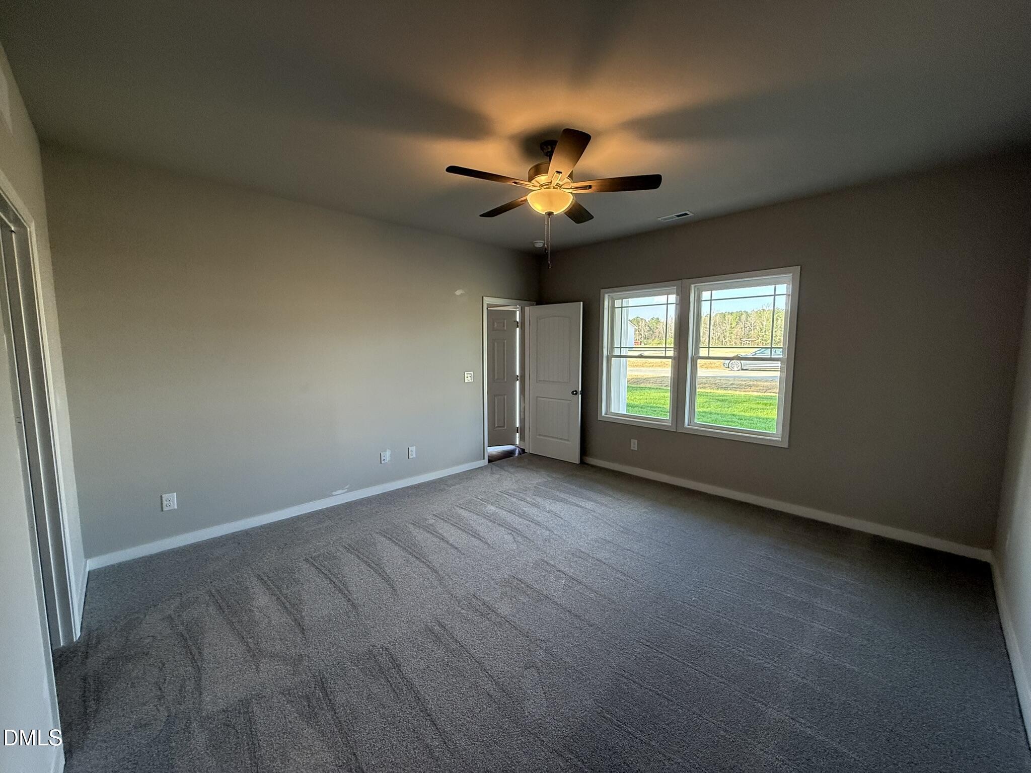 180 Jacobs Ridge Drive Four Oaks, NC 27524 - Photo 11 of 20 an empty room with windows and fan