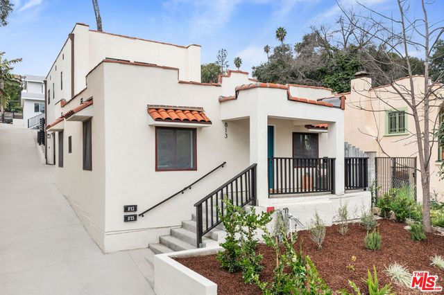 a view of a house with brick walls and flower plants
