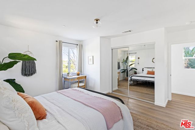 a bedroom with a bed and wooden floor