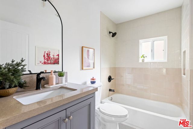 a bathroom with a granite countertop sink a toilet and a bathtub