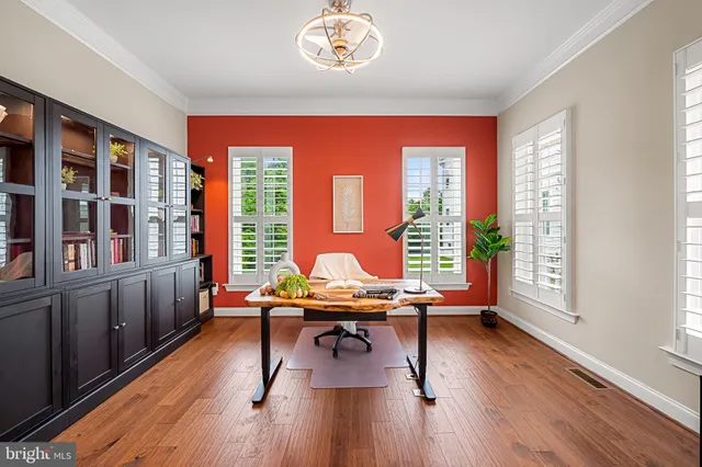 an open kitchen with wooden floor and stainless steel appliances