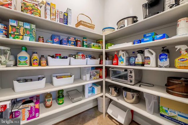 a dining room with stainless steel appliances kitchen island granite countertop a table chairs and a refrigerator