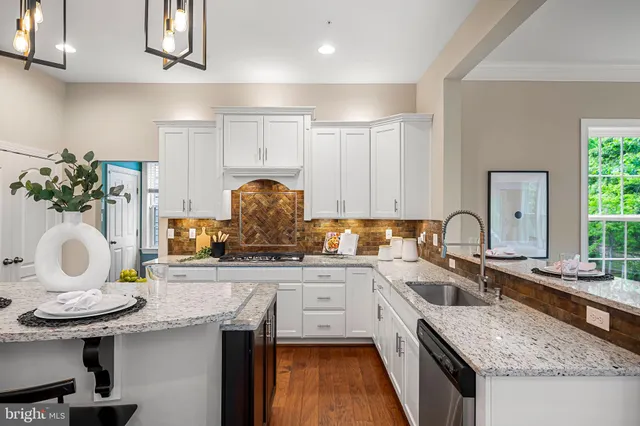 a bedroom with a bed chandelier and a large window