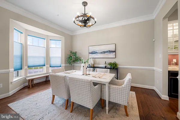 a view of a livingroom with furniture wooden floor windows and a chandelier