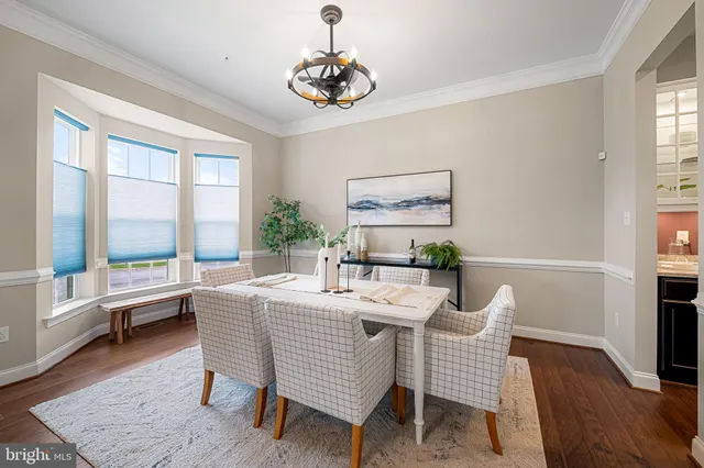 a view of a livingroom with furniture wooden floor windows and a chandelier
