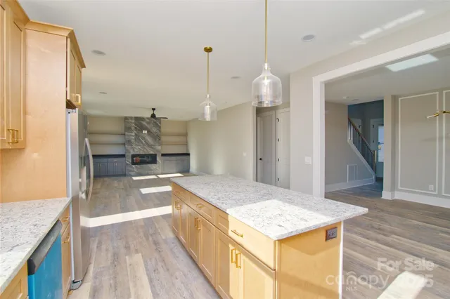 a open kitchen with kitchen island a sink granite counter tops and a view of living room