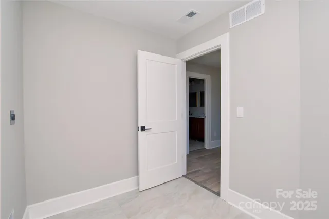 a view of an empty room with closet and a window