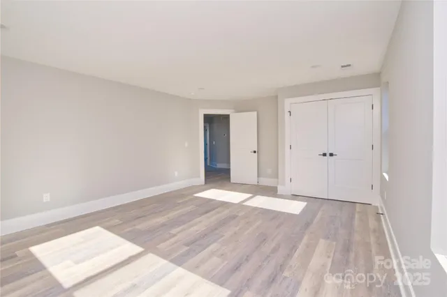 a view of an empty room with wooden floor