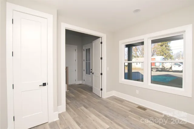 a view of a room with wooden floor and a window