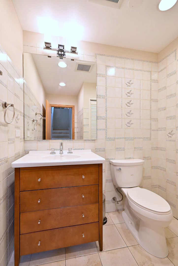 2350 North Sayre Avenue, Unit G Chicago, IL 60707 - Photo 12 of 30 a bathroom with a sink a toilet and mirror