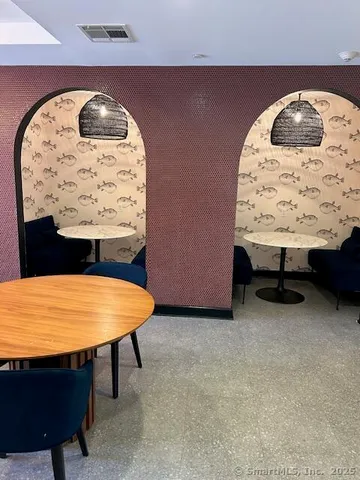 an empty room with a table and wall painting