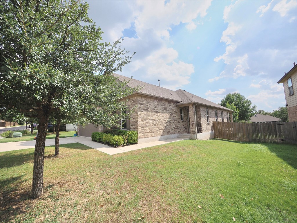 a view of a yard with wooden fence