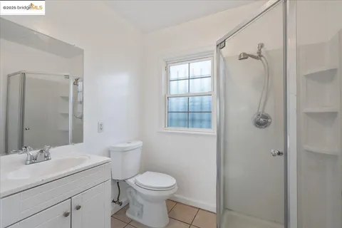 a bathroom with a granite countertop sink a toilet and shower