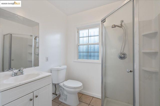 a bathroom with a granite countertop sink a toilet and shower