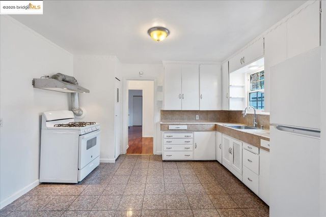 a kitchen with a stove sink and cabinets