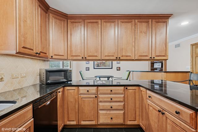 a kitchen with granite countertop a sink a stove and cabinets