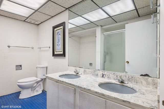 a bathroom with a granite countertop sink toilet and mirror
