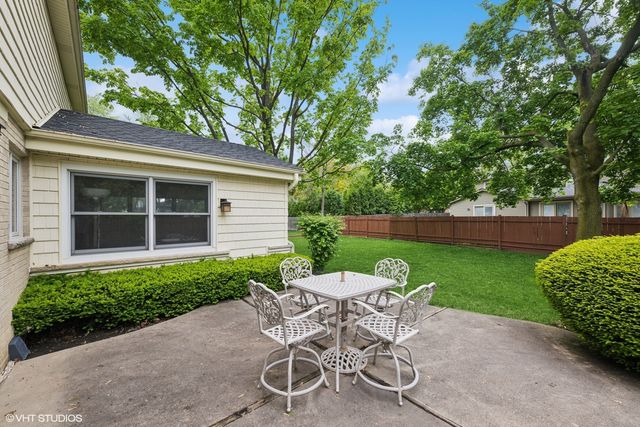 a view of a chair and table in backyard of the house