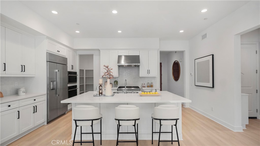 138 Jayhawk Irvine, CA 92602 - Photo 11 of 50 a kitchen with stainless steel appliances kitchen island granite countertop a dining table chairs and white cabinets