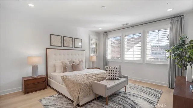 a bedroom with a large bed and a potted plant