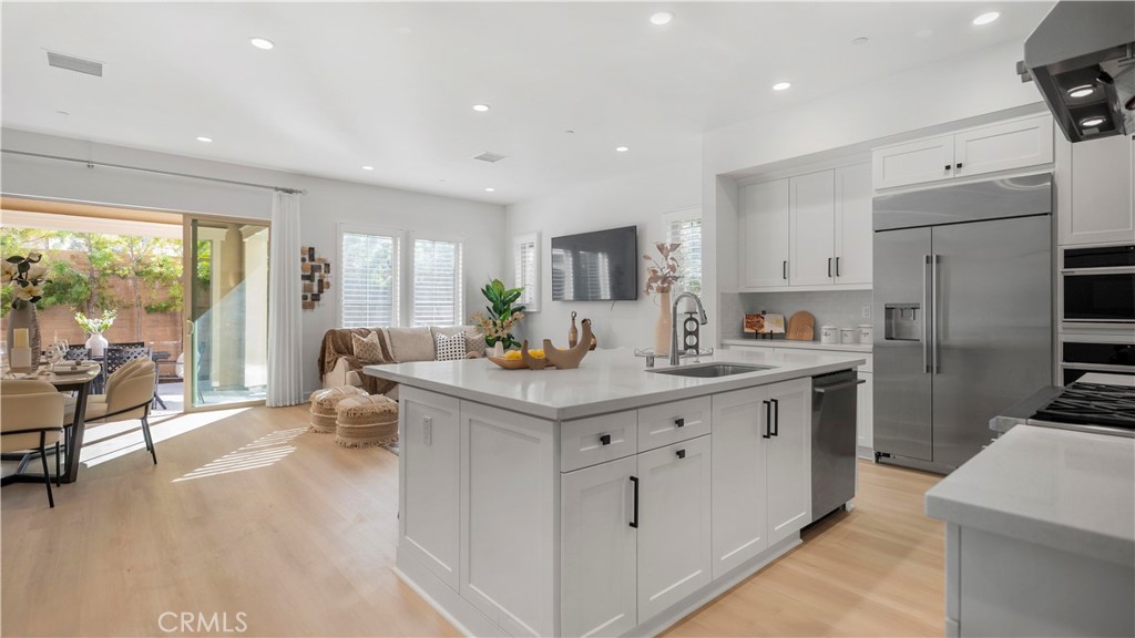 138 Jayhawk Irvine, CA 92602 - Photo 6 of 50 a kitchen with white cabinets and stainless steel appliances