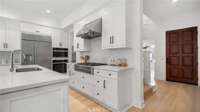 a kitchen with white cabinets and stainless steel appliances