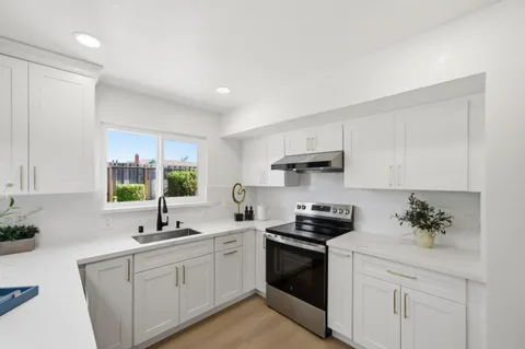 a kitchen with white cabinets and white appliances