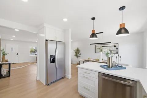 a kitchen with stainless steel appliances granite countertop a sink and a refrigerator
