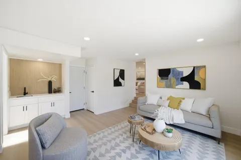 a living room with furniture and view of kitchen