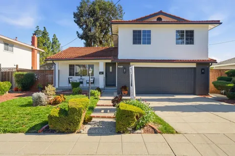 a front view of a house with a yard and outdoor seating