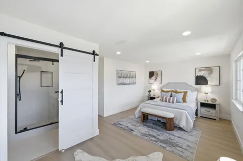 a spacious bedroom with a bed and a refrigerator