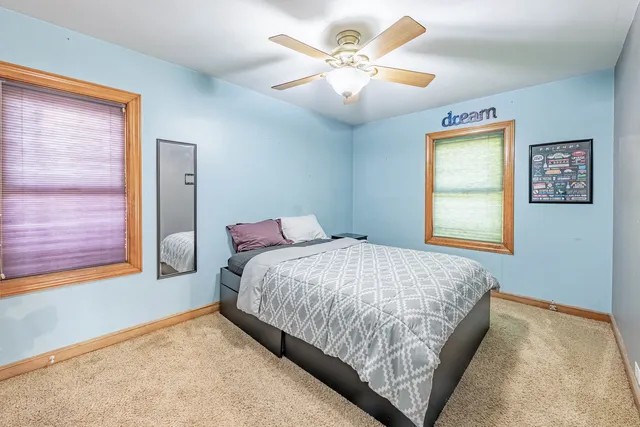 a bedroom with a bed chandelier and a window