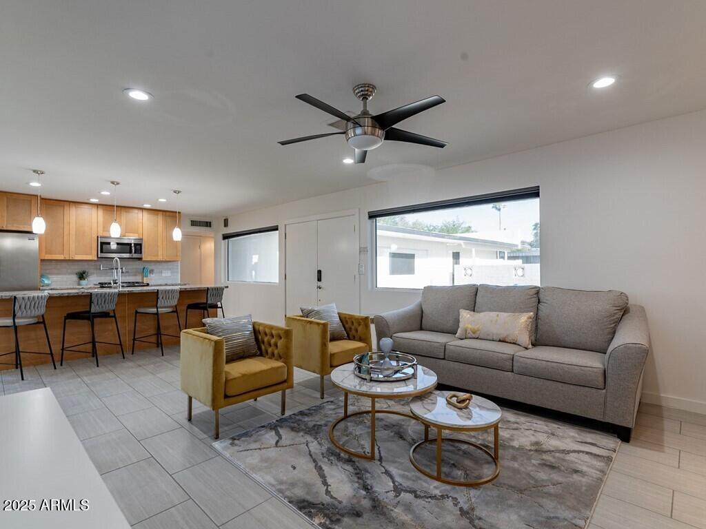 3302 East Turquoise Avenue Phoenix, AZ 85028 - Photo 11 of 59 a living room with furniture a ceiling fan and a window