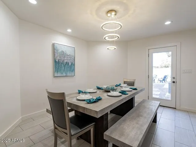 a kitchen with stainless steel appliances granite countertop wooden cabinets a dining table and chairs