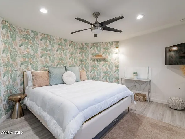 a large white bed in a bedroom next to a window