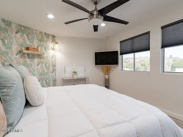 a bedroom with a bed and a wall painting