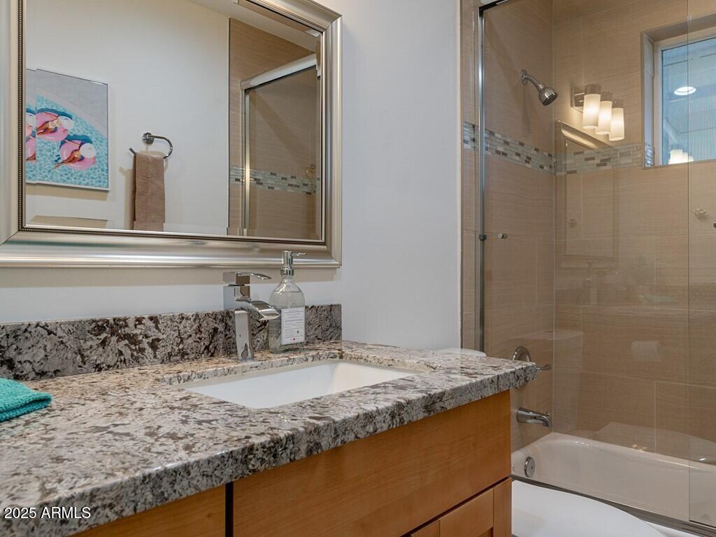 3302 East Turquoise Avenue Phoenix, AZ 85028 - Photo 35 of 59 a bathroom with a granite countertop sink a mirror and shower