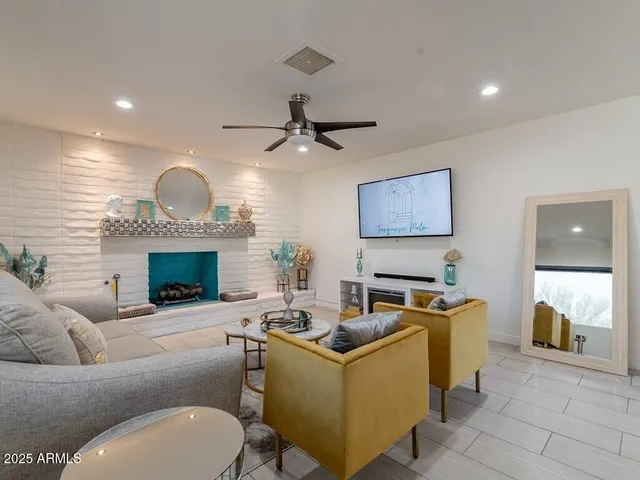 a living room with furniture a ceiling fan and a window