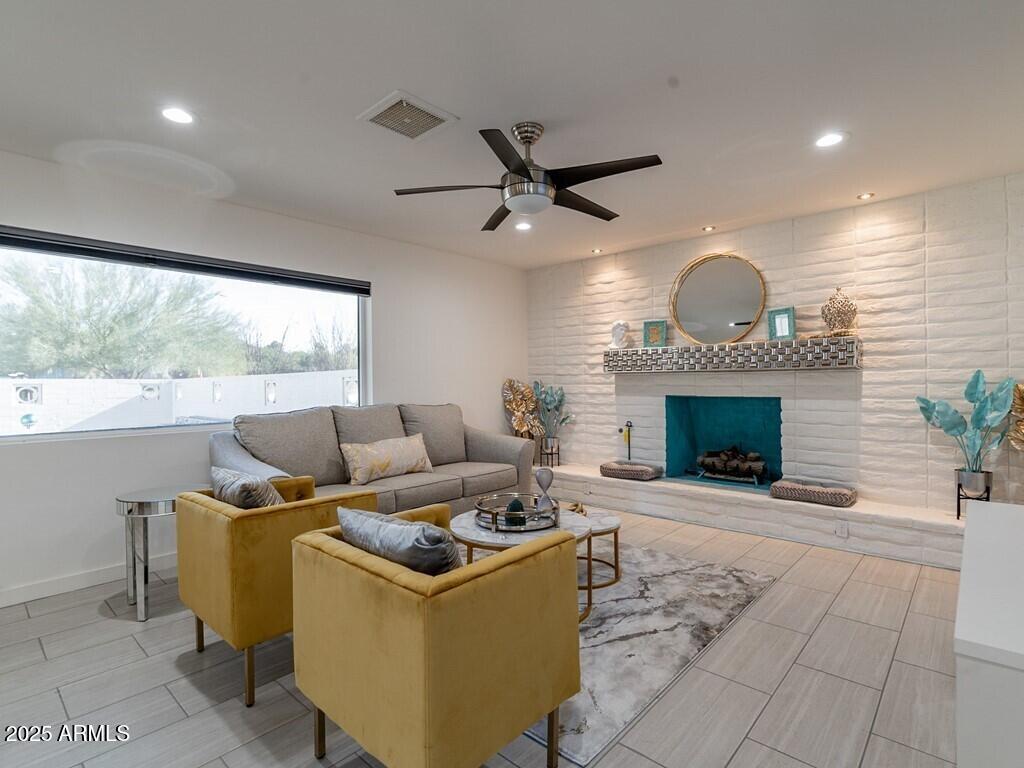 3302 East Turquoise Avenue Phoenix, AZ 85028 - Photo 10 of 59 a living room with furniture a fireplace and a large window
