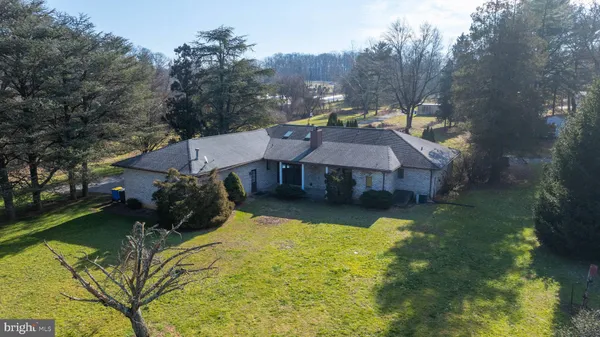 a view of a house with a big yard and large trees