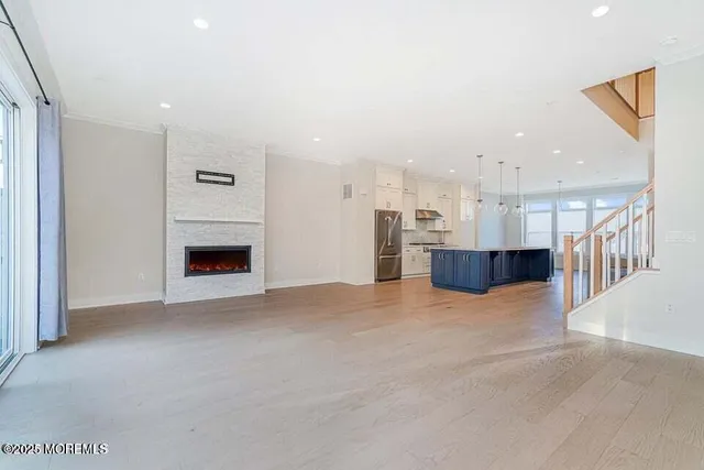 an empty room with kitchen and fireplace