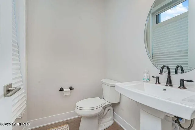 a bathroom with a sink a toilet and a mirror