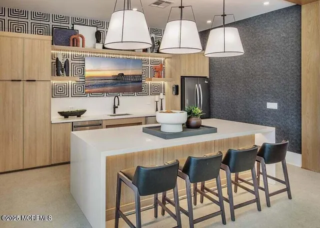 a kitchen with stainless steel appliances a dining table chairs and refrigerator