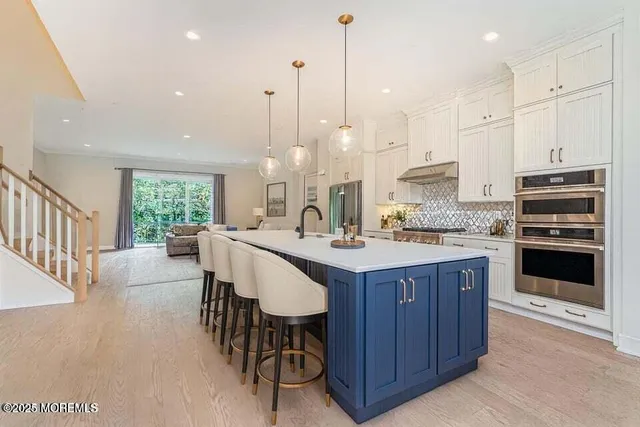 a kitchen with kitchen island granite countertop a stove a sink a center island and a window