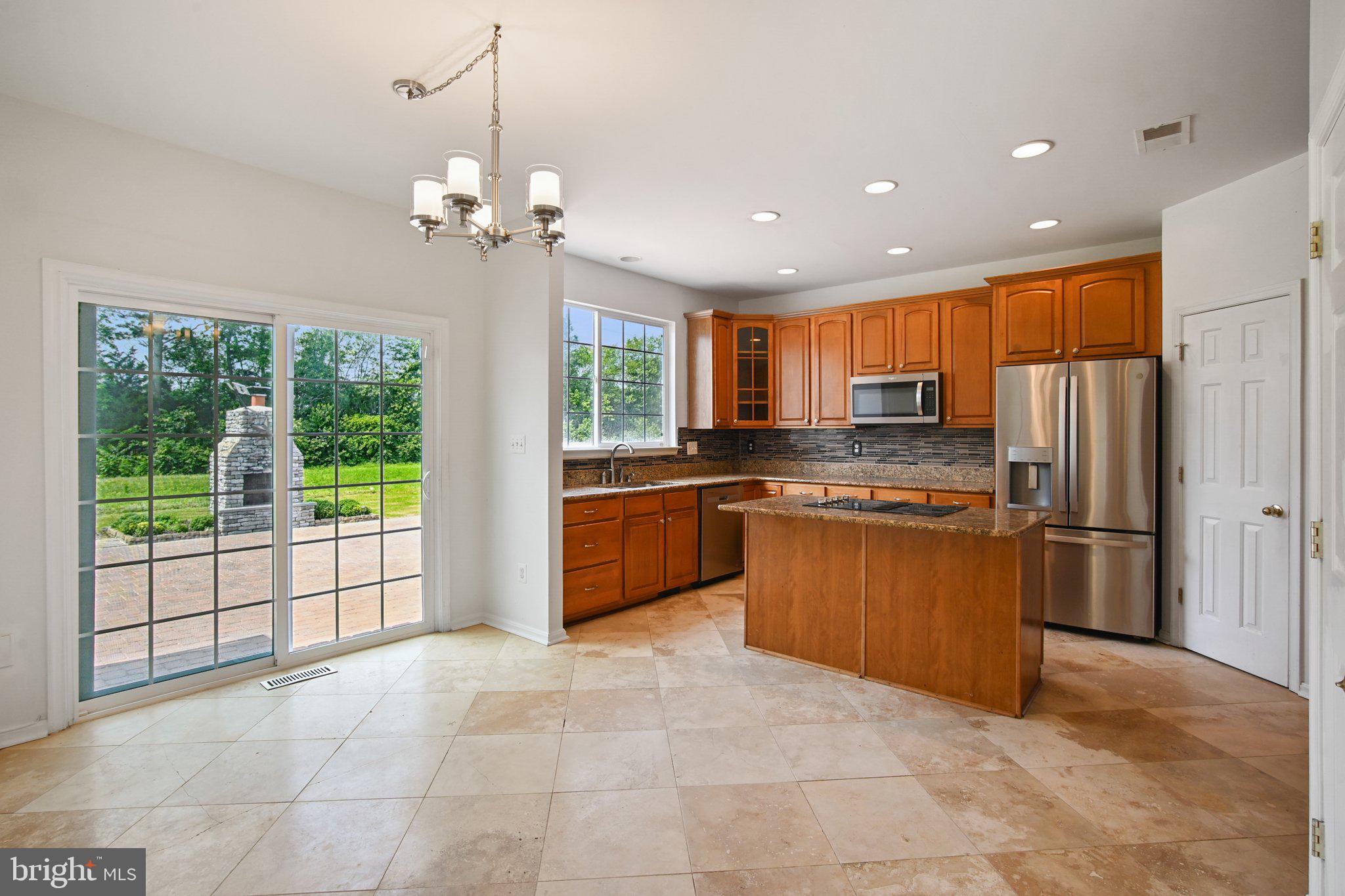 1624 Osprey Circle Cambridge, MD 21613 - Photo 12 of 45 a kitchen with stainless steel appliances granite countertop a refrigerator oven a sink with a dining table and chairs