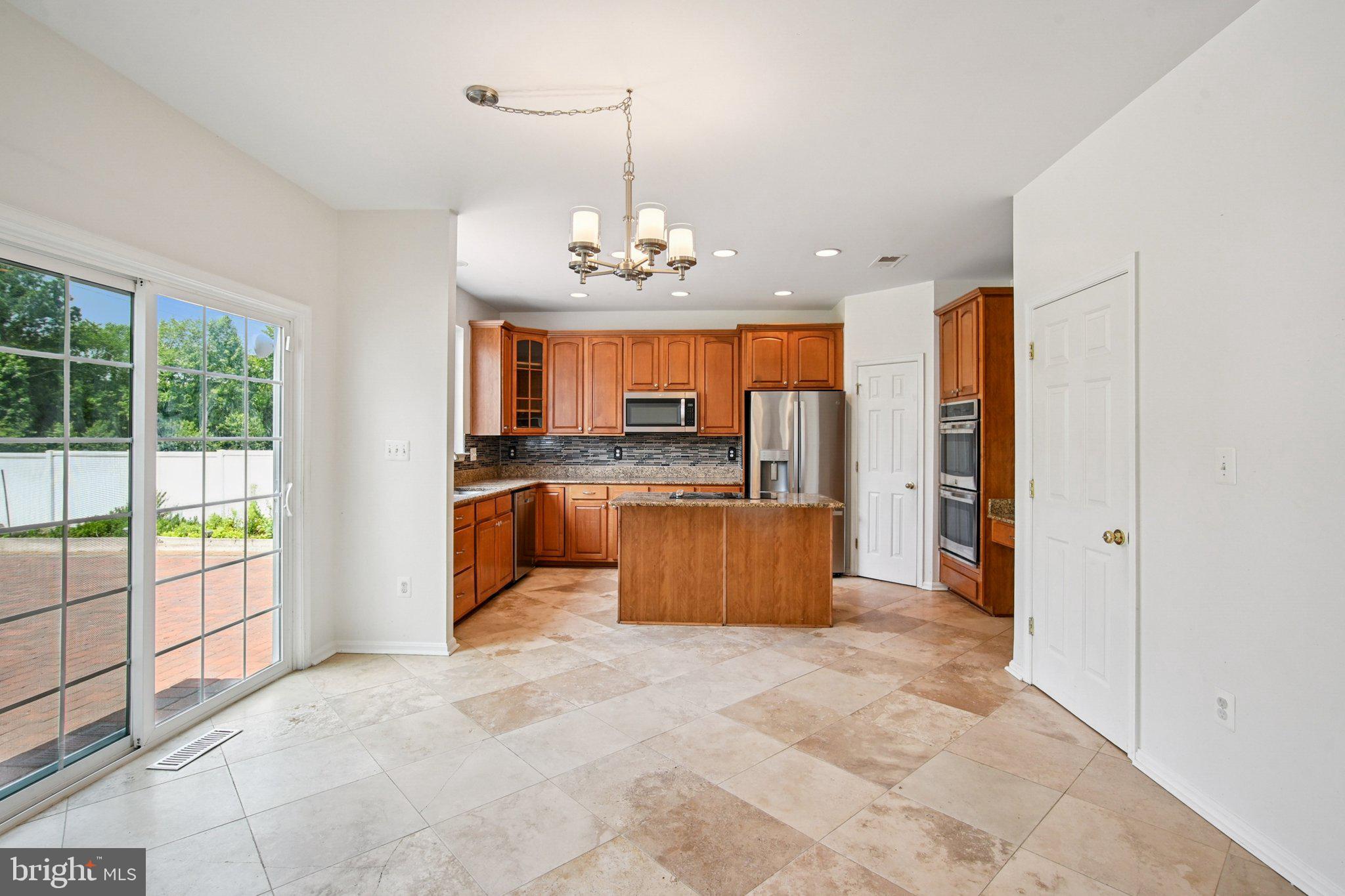 1624 Osprey Circle Cambridge, MD 21613 - Photo 13 of 45 a kitchen with stainless steel appliances kitchen island granite countertop a refrigerator and a sink