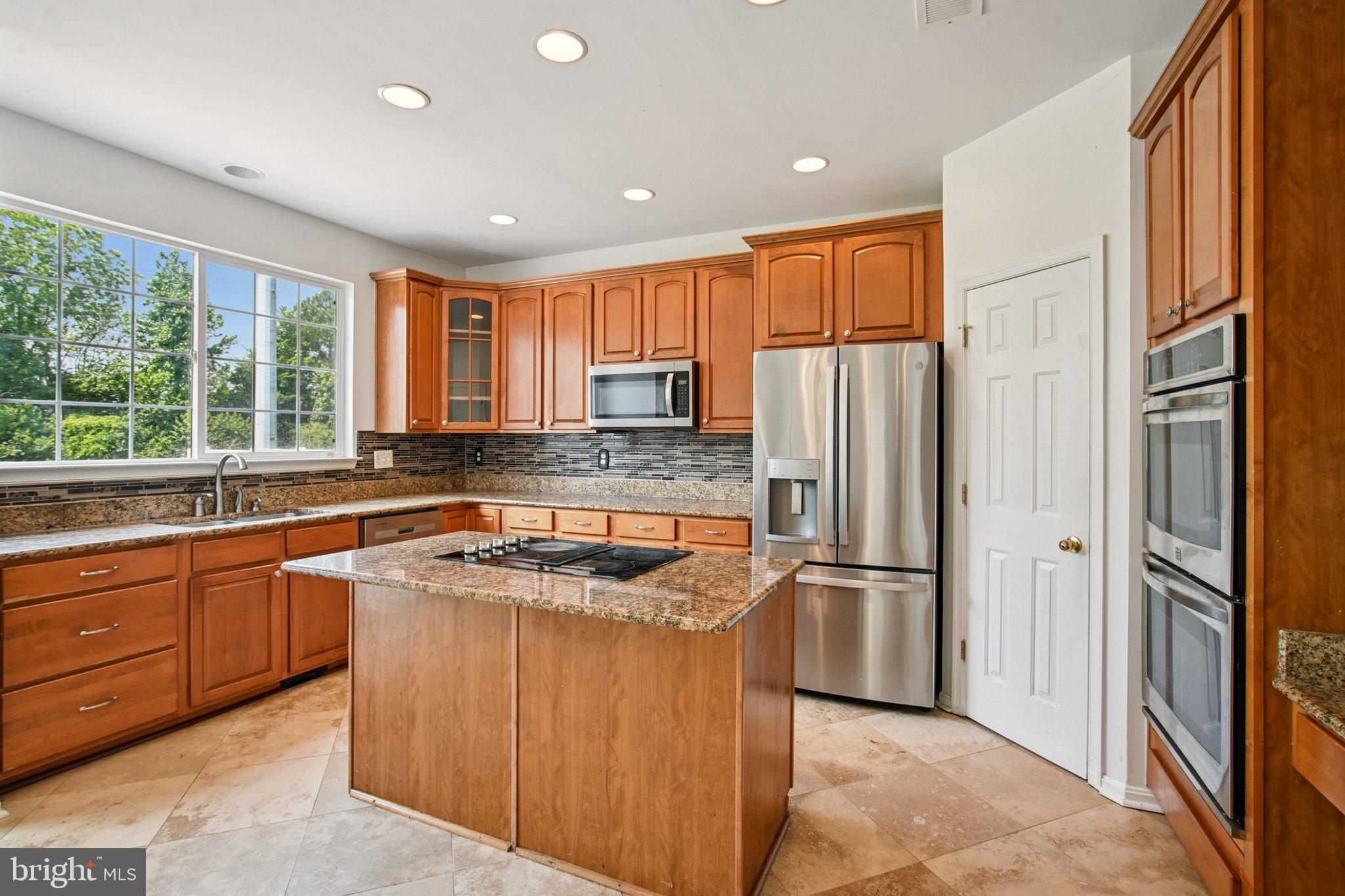 1624 Osprey Circle Cambridge, MD 21613 - Photo 14 of 45 a kitchen with stainless steel appliances granite countertop a refrigerator a sink a stove a washer dryer and a refrigerator